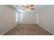 Neutral carpeted bedroom features a ceiling fan, and two doors with fresh paint at 6509 Charter Way, Lithonia, GA 30058
