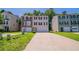 Traditional-style townhome with two-car garage, well-maintained lawn and colorful accents on a sunny day at 6509 Charter Way, Lithonia, GA 30058