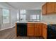 Kitchen view, showcasing sleek black dishwasher, stainless steel sink, and wood-look flooring near a dining area at 6509 Charter Way, Lithonia, GA 30058