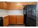 Efficient kitchen with light countertops, wooden cabinets, and modern black appliances, well-lit and functional at 6509 Charter Way, Lithonia, GA 30058