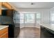 A well-lit kitchen area highlights dark appliances with warm-toned cabinetry and an adjacent breakfast nook at 6509 Charter Way, Lithonia, GA 30058