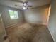 This bedroom has neutral walls and carpet and also features a ceiling fan and a window at 6668 Prinston Cir, Douglasville, GA 30135