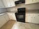 Close-up of the kitchen's black oven and cooktop set against white cabinets and neutral countertops at 6668 Prinston Cir, Douglasville, GA 30135