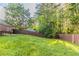 A large backyard area is surrounded by a wooden fence and mature trees at , Lithonia, GA 30038