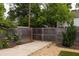 Wooden fence with gate and concrete driveway adjacent to artificial turf and landscaping at 1354 Mcpherson Se Ave, Atlanta, GA 30316