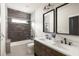 Bathroom featuring double sinks, stylish mirrors, and a stone-accented shower at 1354 Mcpherson Se Ave, Atlanta, GA 30316