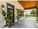 Inviting front porch with stained wood ceiling, stylish railing, modern lighting, and potted plants at 1354 Mcpherson Se Ave, Atlanta, GA 30316