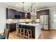 Modern kitchen with dark cabinets, stainless steel appliances, and a waterfall island with seating at 1354 Mcpherson Se Ave, Atlanta, GA 30316