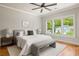 This main bedroom has hardwood floors, a ceiling fan, and a view of the neighborhood at 1354 Mcpherson Se Ave, Atlanta, GA 30316