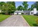 Well-maintained home featuring a long driveway, green lawn, and manicured landscaping at 1915 Cooper Landing Se Dr, Smyrna, GA 30080