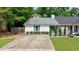 Charming house exterior featuring a long driveway, brick accents, and tasteful landscaping at 1915 Cooper Landing Se Dr, Smyrna, GA 30080