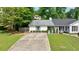 Charming house exterior featuring a long driveway, brick accents, and tasteful landscaping at 1915 Cooper Landing Se Dr, Smyrna, GA 30080
