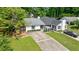Charming house exterior featuring a long driveway, brick accents, tasteful landscaping and car at 1915 Cooper Landing Se Dr, Smyrna, GA 30080