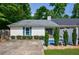 Charming single-story home with white brick, blue shutters and a welcoming, landscaped front yard at 1915 Cooper Landing Se Dr, Smyrna, GA 30080