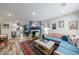 Open-concept living room with a fireplace, wood floors, and colorful furniture with eclectic art at 1915 Cooper Landing Se Dr, Smyrna, GA 30080