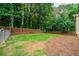 Large, partially fenced backyard with a mix of grass and pine straw ground cover at 4495 Riders Ridge Trl, Snellville, GA 30039
