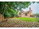 Expansive backyard with a deck, patio, mature trees, and a fenced perimeter at 4495 Riders Ridge Trl, Snellville, GA 30039