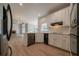 Open kitchen with stainless steel appliances and white cabinets overlooking the living room at 4495 Riders Ridge Trl, Snellville, GA 30039