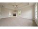 Expansive carpeted main bedroom featuring a fireplace and ceiling fan at 4495 Riders Ridge Trl, Snellville, GA 30039