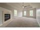 Main bedroom with tray ceiling, fan, fireplace and large windows at 4495 Riders Ridge Trl, Snellville, GA 30039