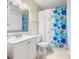 Inviting bathroom with floral curtain, a modern white vanity and glass shelves adding a touch of elegance at 472 Sherman Way, Decatur, GA 30033