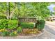 Well-maintained community entrance sign surrounded by mature trees and colorful landscaping at 472 Sherman Way, Decatur, GA 30033
