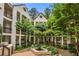 Serene condo courtyard with a central fountain, lush trees, and surrounding buildings at 472 Sherman Way, Decatur, GA 30033