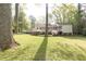 A sprawling backyard featuring a house with a large deck, lush lawn, and mature trees at 70 Mount Paran Ne Rd, Atlanta, GA 30342