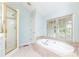 Bathroom featuring a large soaking tub, walk-in shower, and large window at 70 Mount Paran Ne Rd, Atlanta, GA 30342