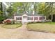 Charming one story home featuring blooming azaleas, red shutters, and mature trees at 70 Mount Paran Ne Rd, Atlanta, GA 30342