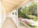 Covered porch with white railings overlooks a lush garden with colorful azaleas at 70 Mount Paran Ne Rd, Atlanta, GA 30342