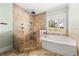 Bathroom with tile shower, soaking tub, and window showcasing outdoor view at 90 Alcovy Reserve Way, Covington, GA 30014