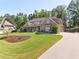 Landscaped front yard with lush lawn, mature trees, and a long driveway to a three-car garage at 90 Alcovy Reserve Way, Covington, GA 30014