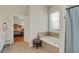 Bright bathroom featuring a soaking tub, tiled floors, and a window with blinds at 125 Rabbits Run, Fayetteville, GA 30215