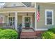 Welcoming front porch with beautiful door, brick steps, and an American flag at 125 Rabbits Run, Fayetteville, GA 30215