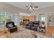 Spacious living room with hardwood floors, ceiling fan, and kitchen view at 125 Rabbits Run, Fayetteville, GA 30215