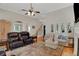 Bright living room with tall ceilings, hardwood floors, fireplace, and plush furniture at 125 Rabbits Run, Fayetteville, GA 30215
