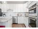 Modern kitchen with granite countertops, stainless steel appliances including double oven, and stylish white cabinetry at 41 Balsam Dr, Dallas, GA 30157