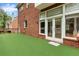 Brick home featuring a backyard with an artificial turf lawn and large windows at 470 Manor Oak Se Ln, Marietta, GA 30067