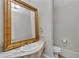 Powder room with marble countertop, gold fixtures, and decorative mirror at 470 Manor Oak Se Ln, Marietta, GA 30067