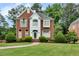 Charming brick home featuring a manicured lawn and lush landscaping at 470 Manor Oak Se Ln, Marietta, GA 30067