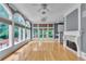Sunroom featuring a fireplace, hardwood floors, large windows with shades, and a ceiling fan at 470 Manor Oak Se Ln, Marietta, GA 30067
