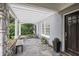 Charming covered porch with stone floor, bench seating, and view of the front yard at 635 Wilson Nw Rd, Atlanta, GA 30318