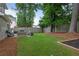 Green backyard area with a stone patio area and a privacy fence with mature shade trees at 1217 Club Walk Ne Dr, Brookhaven, GA 30319