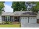Charming gray single-story home with a well-manicured front yard and a convenient two-car garage at 1217 Club Walk Ne Dr, Brookhaven, GA 30319