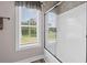 A clean bathroom featuring tile accents, a glass shower door, and a bright window at 1423 Hillcrest Rd, Bowdon, GA 30108