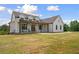 Gorgeous home showcasing its covered front porch, black framed windows, vertical siding, and sprawling front lawn at 1423 Hillcrest Rd, Bowdon, GA 30108