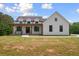 Beautiful home with a covered front porch, dark framed windows, vertical siding, and well-maintained lawn at 1423 Hillcrest Rd, Bowdon, GA 30108