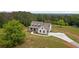 Stunning aerial view of a two-story home with a large yard and long driveway surrounded by dense, mature trees at 1423 Hillcrest Rd, Bowdon, GA 30108