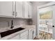 Laundry room with ample counter space, undermount sink, and view into a room with modern decor at 1423 Hillcrest Rd, Bowdon, GA 30108